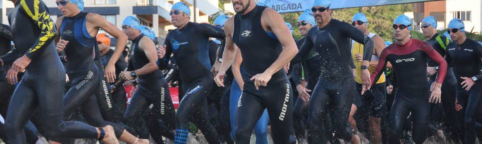 Atletas largam e correm para o mar, para a primeira etapa do triatlo de Caiobá, litoral do Paraná